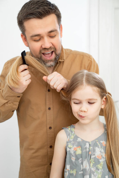 dad makes ponytails of her little daughter - Photo, Image