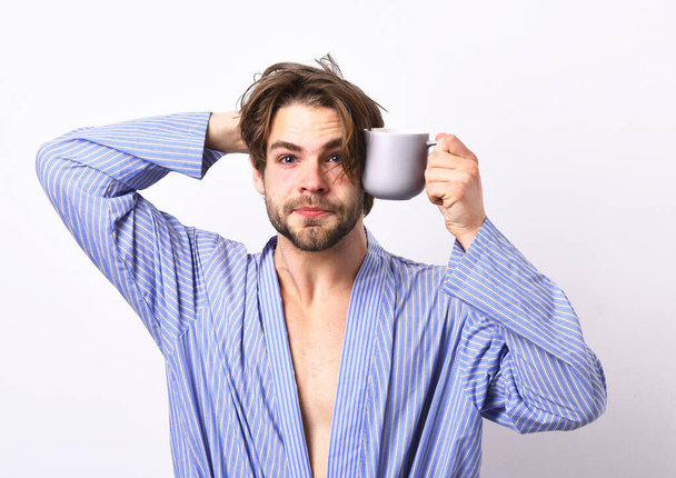 Man with beard in blue dressing gown on grey background. - 写真・画像
