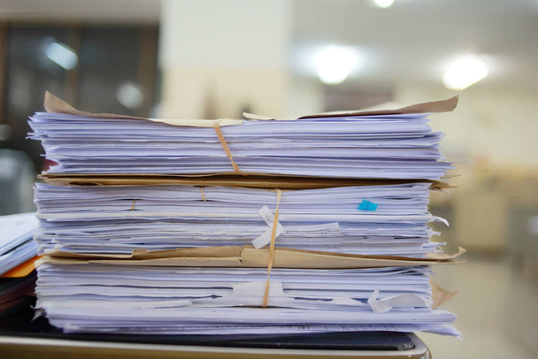 Бумажные деловые документы незавершенной упаковки в архив офисного стола, в архив анализа рынка и учитывает размер будущей прибыли на стол офиса
. - Фото, изображение