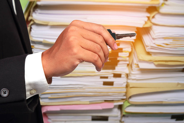 Businessmen hold the key and Paper documents stacked background. Concept the path to win success. - Photo, Image