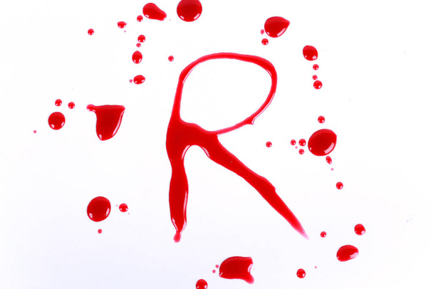 Impresión sangrienta sobre un fondo blanco con las letras R
 - Foto, Imagen