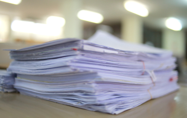 Бумажные деловые документы незавершенной упаковки в архив офисного стола, в архив анализа рынка и учитывает размер будущей прибыли на стол офиса
. - Фото, изображение