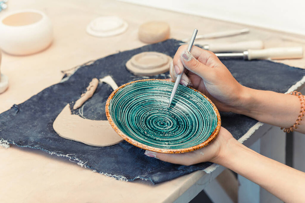 девушка ремесленник, работающая с глиняной посудой на продажу в своем магазине. Концепция керамического бизнеса для концепции художника
 - Фото, изображение