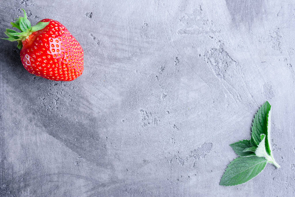 Fresh strawberries and mint on a gray concrete background with copy space, top view - Photo, Image