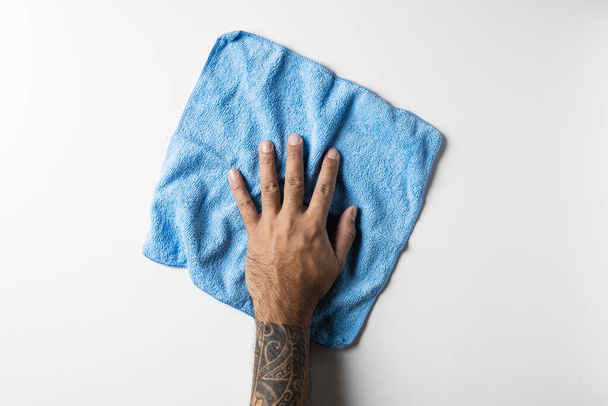 bovenaanzicht van de hand met blauwe schoonmaakdoek geïsoleerd op witte achtergrond - Foto, afbeelding