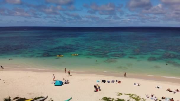 4K drone footage of two kayaks kayaking in shoreline with beach and cristal clear water coral reef at Lanikai beach park, Oahu, Hawaii, USA.Tilt movement. - Felvétel, videó