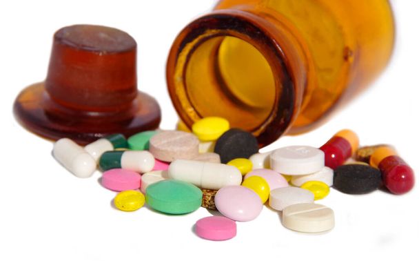 Médicaments et pilules. Médicaments multicolores sur fond blanc gros plan. Flacon en verre brun avec pilules
. - Photo, image