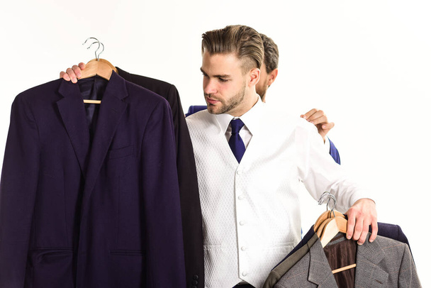 Businessman chooses outfit with hand of assistant behind him - Foto, imagen
