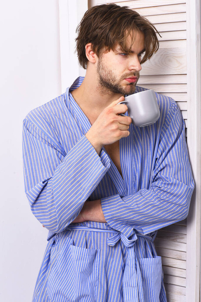 Sportsman in home or bath clothes drinks tea or coffee. - Foto, Imagem