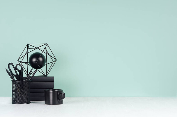 Fresh home simple workspace with black stationery, books, coffee cup, abstract modern sculpture in elegant green mint menthe interior on white wood desk, copy space. - Foto, Bild