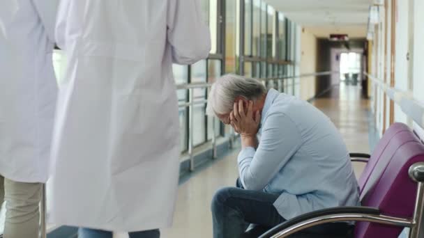 smutny i przygnębiony azjatycki stary człowiek siedzi w fotelu w szpitalnym korytarzu  - Materiał filmowy, wideo