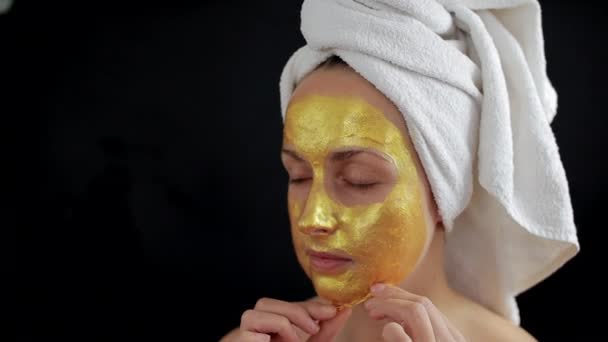 Frau entfernt goldene Hydrogelmaske im Gesicht - Filmmaterial, Video