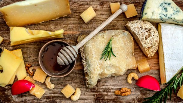 Cheese assortment on wooden board - Фото, изображение