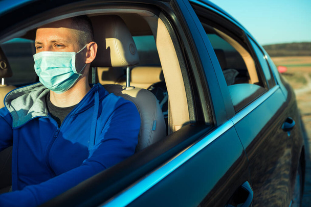 Man in the medical mask in car. coronavirus, disease, infection, quarantine, covid-19 - Фото, изображение