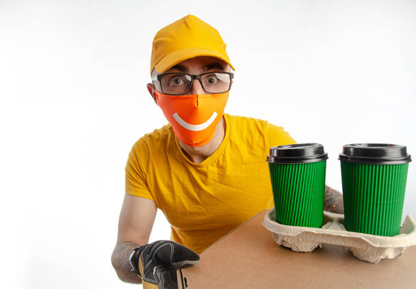 o cara entregando pacotes em uma máscara à prova de vírus, o mensageiro com café e pizza
 - Foto, Imagem