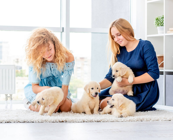 Girls playing with puppies - Foto, afbeelding