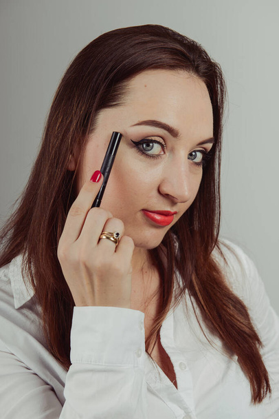 メイクアップ用の化粧品ブラシのセットを持つ女性、灰色で隔離 - 写真・画像