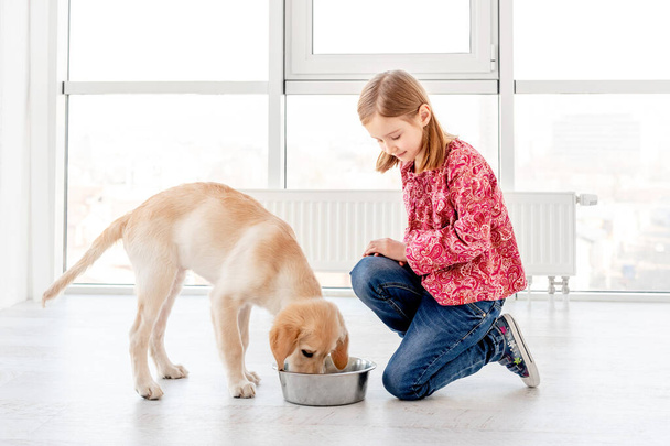 Girl giving food to dog - Fotoğraf, Görsel