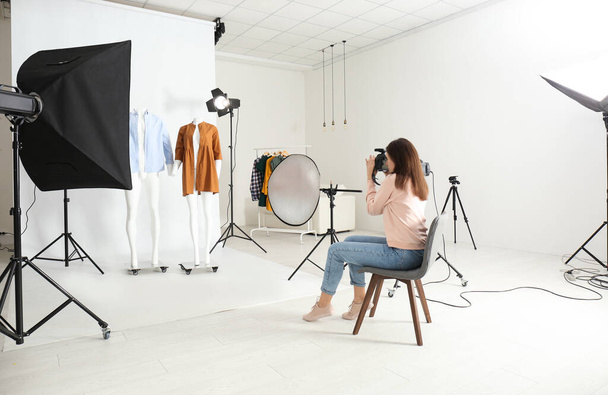 Professional photographer taking picture of ghost mannequins with modern clothes in photo studio - Foto, Imagem