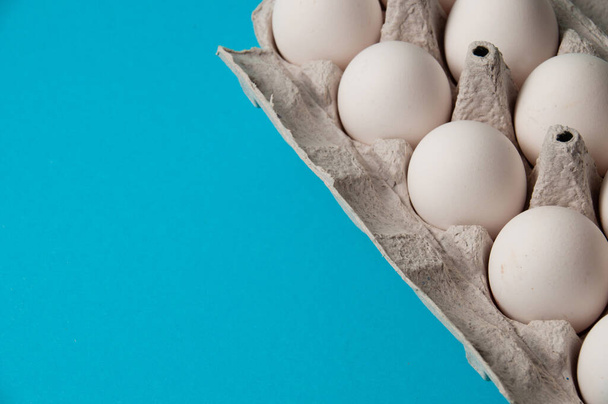 Eggs in a tray on blue background. Conceptual photo with place for text. - Photo, Image