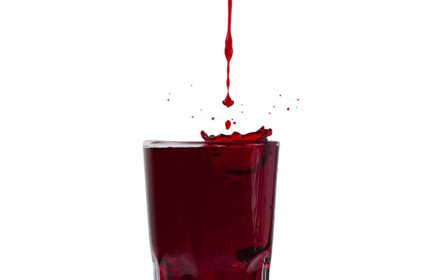 Grape and pomegranate juice pouring into glass, isolate on a white background - Fotó, kép