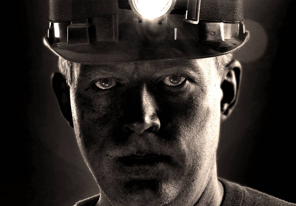 Fatigué visage sale de mineur de charbon dans le casque avec de la lumière. Portrait détaillé du travailleur minier
. - Photo, image