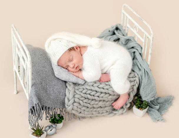 Beautiful newborn on tiny bed - Фото, изображение