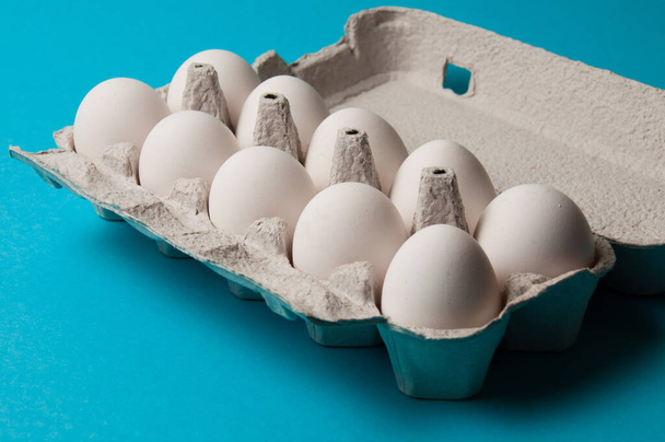 Mavi arka planda bir tepside yumurtalar. Metin için yeri olan kavramsal fotoğraf. - Fotoğraf, Görsel
