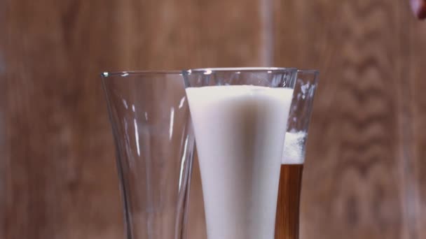 A glass and a mug of tasty beer stand on a brown background. Fragrant beer lit by beautiful light stimulates appetite. - Filmati, video