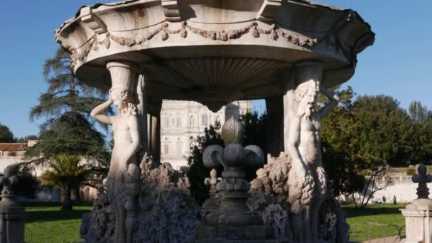 Amor Fontána ve Villa Doria Pamphili veřejného parku v Římě, Itálie, kruhový povodí je podporován čtyřmi pilíři v vnější fasádě, z nichž dva muži a dvě ženy fauny střídají - Záběry, video