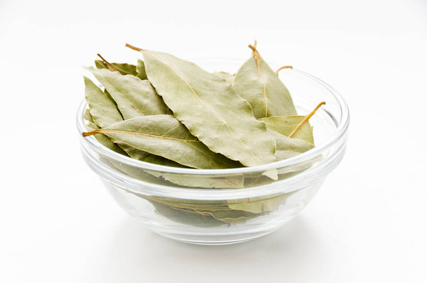 Sušené Bay listí v zásobníku misky na bílém pozadí - Fotografie, Obrázek