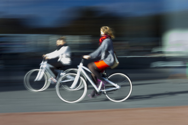 dwie kobiety na niewyraźne rowery w profilu - Zdjęcie, obraz