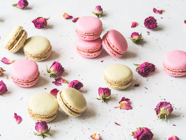 Composition of sweet macaron cookies and dry flowers on light background, - Photo, Image