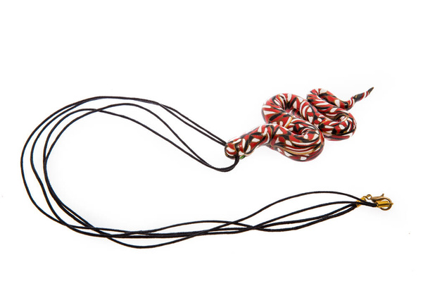 Handgemaakte ketting in de vorm van een slang geïsoleerd op een witte achtergrond. Vrouwelijke accessoires, decoratieve ornamenten en sieraden. Mode- en stijlconcept. - Foto, afbeelding
