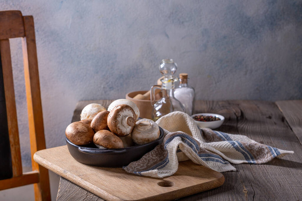 Champignon mushrooms and spices on a wooden table. Cooking concept. - Fotografie, Obrázek