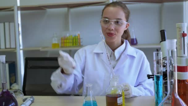 Wetenschappers gebruiken pipet om vloeistof te zuigen en druppelen op gegradueerde cilinder voor wetenschappelijke experimenten - Video