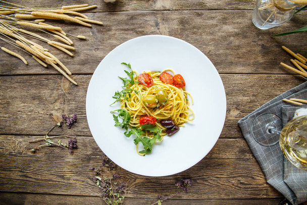 Spaghettis italiens aux olives et tomates
 - Photo, image