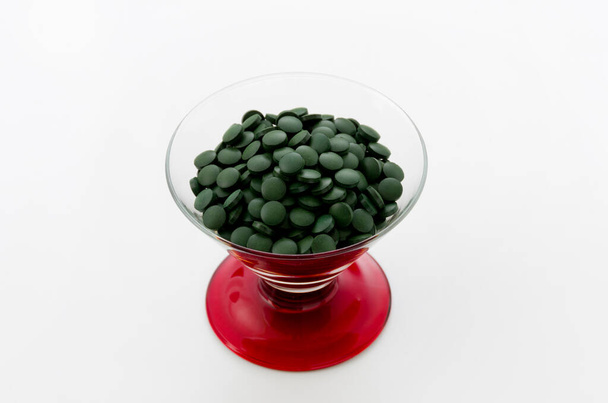 green pills,Spirulina tablets in glass - Foto, afbeelding