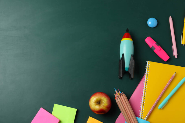 Bright toy rocket and school supplies on chalkboard, flat lay. Space for text - Fotoğraf, Görsel