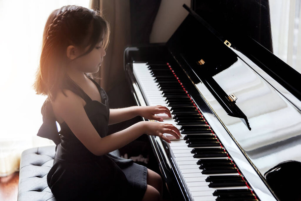 Aasialainen tyttö lapset käytännössä soittaa pianoa varten taito musiikin kyky tulevaan ammattiin
. - Valokuva, kuva