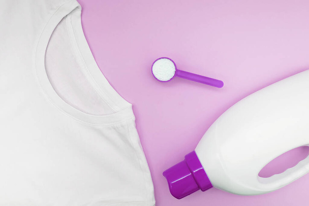 Clean white t-shitr, powder washing detergent and plastic bottle of liquid on pink background - Fotoğraf, Görsel