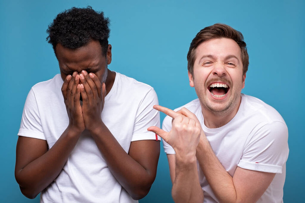 白人の男は彼の友人を笑います。彼は議論や競争に勝った. - 写真・画像