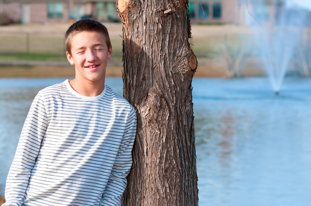 przystojny nastolatek, opierając się na drzewo - Zdjęcie, obraz