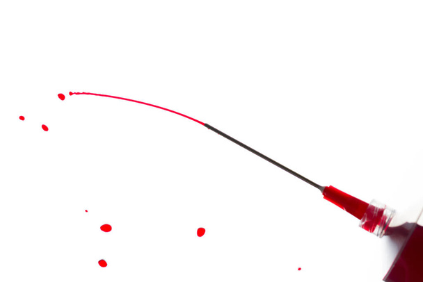 Jeringa chorreando líquido rojo sobre un fondo blanco
 - Foto, imagen