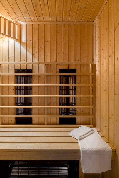 Finnish style sauna with bright conifer wood and ceiling lights on - Foto, Bild