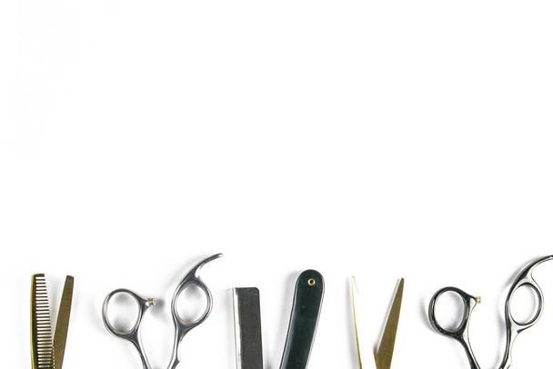 Schere, Haarschneidemaschine, Kämme, gefährliches Rasiermesser auf weißem Laken auf schwarzem Hintergrund. Friseurkonzept. - Foto, Bild