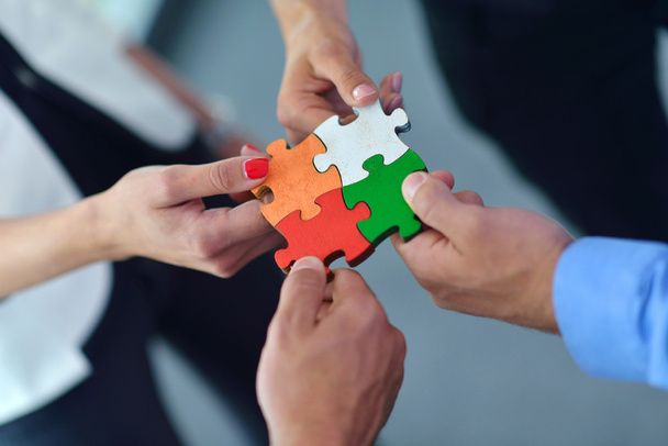 Group of business people assembling jigsaw puzzle - Foto, imagen