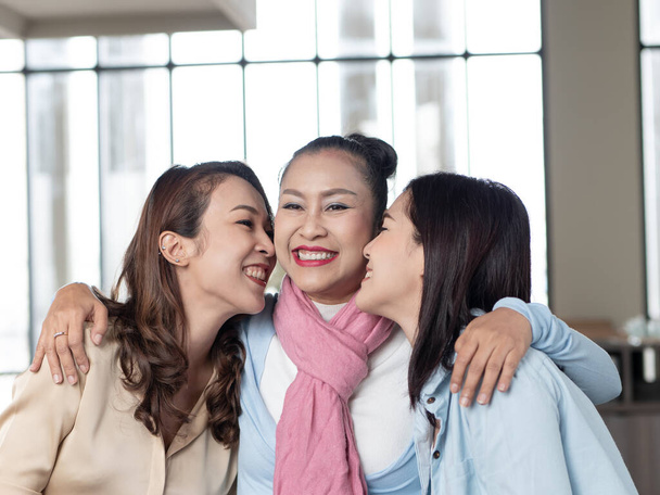 Happy Asian family, Mother embracing her daughter and kiss cheeks with love in home. happy mother's day - Photo, Image