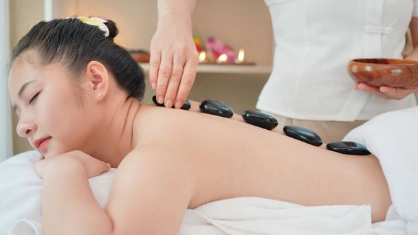 Jeune femme asiatique obtenir massage spa avec massage aux pierres chaudes au salon de beauté spa. Massage relaxant pour la santé
 - Photo, image