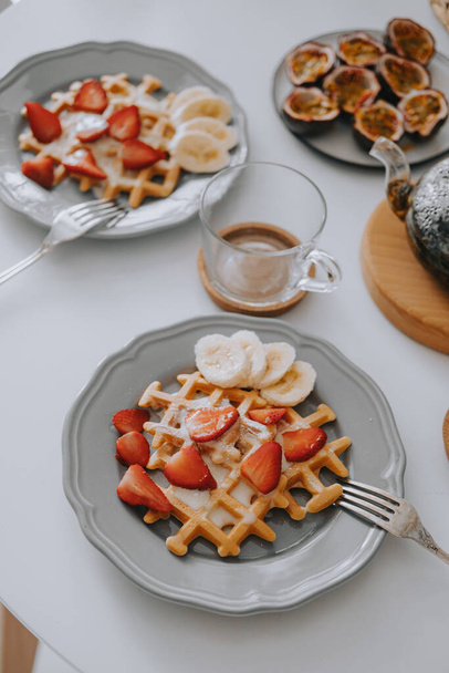 Viennese waffles with strawberries and bananas. Beautiful breakfast - 写真・画像